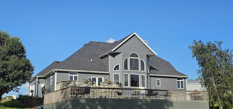Finished Mitten roof and gray siding on a country home in Long Grove, Iowa